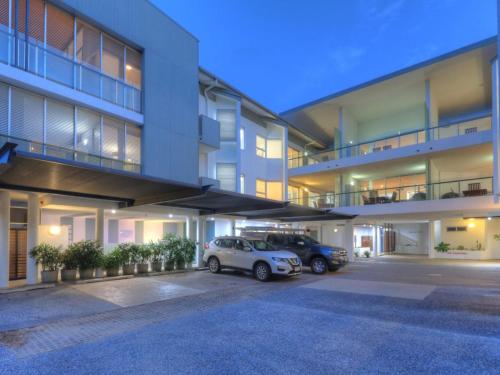 two cars parked in a parking lot in front of a building at Maggies Beachfront Apartment 4 in Horseshoe Bay