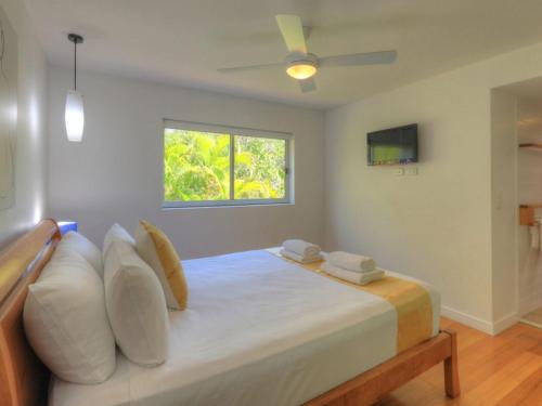 a bedroom with a bed with pillows and a window at Maggies Beachfront Apartment 7 in Horseshoe Bay