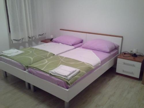 Schlafzimmer mit einem Bett mit rosa und grünen Kissen in der Unterkunft Room in Susak with air conditioning, W-LAN (3865-5) in Susak