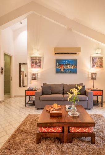 a living room with a couch and a table at Santa Tera Homely 1&2bhk Apartments With Common Pool & Kitchen & Security & Wifi, Near to Candolim in Verem