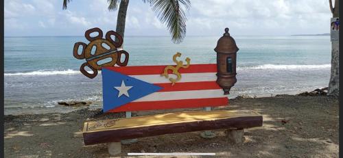 a sign with an american flag and a clock on the beach at Casa Del Mar !!! Ocean front villa in Aguada
