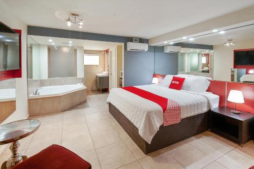 a bedroom with a large bed and a bath tub at OYO Hotel Coral Gables - Miami Airport in Miami