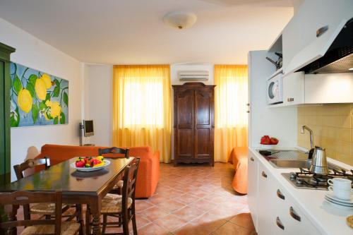a kitchen and a living room with a table and a couch at Residence Degli Agrumi in Taormina