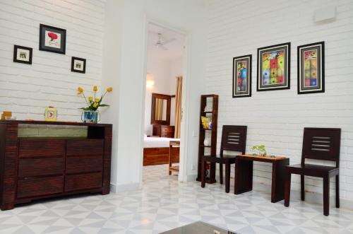 a living room with two chairs and a dresser at Santa Tera Homely 1&2bhk Apartments With Common Pool & Kitchen & Security & Wifi, Near to Candolim in Verem