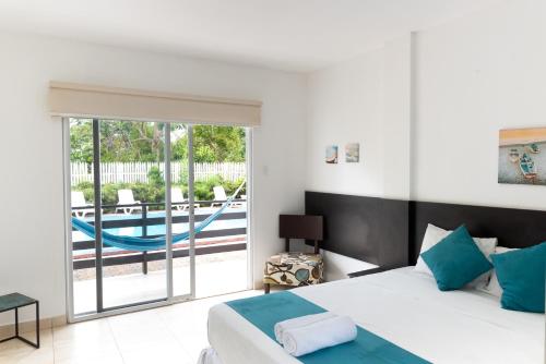 a bedroom with a bed and a sliding glass door at Ocean Blue Hotel in Olón