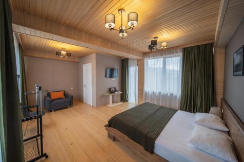 sypialnia z łóżkiem i kanapą w pokoju w obiekcie Hotel Old House Mestia w mieście Mestia