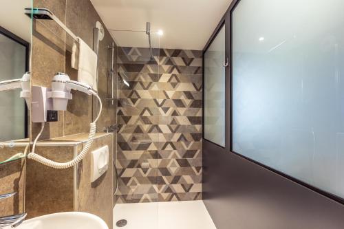 a bathroom with a shower and a sink at The Originals City, H&ocirc;tel H&eacute;lios, Roanne Nord in Mably