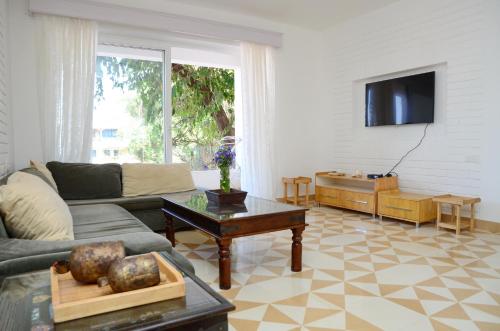 a living room with a couch and a table at Santa Tera Homely 1&2bhk Apartments With Common Pool & Kitchen & Security & Wifi, Near to Candolim in Verem