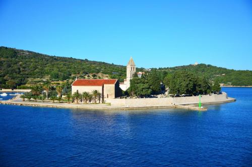 a small island in the middle of the water with a church at Holiday Home (139-2) in Vis