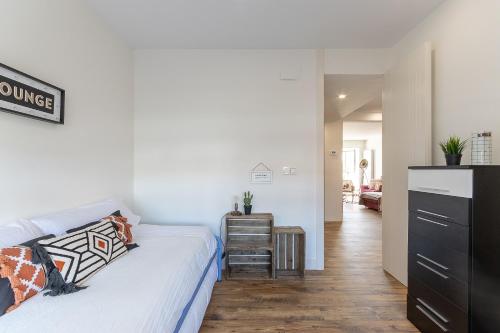a bedroom with a bed and a desk in a room at FIRST LINE SEA VIEWS - Club & Pool & Parking by ALOHA Bilbao in Sopelana