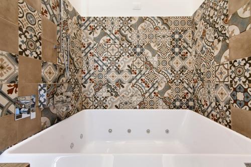 a bath tub in a bathroom with tiles at Palazzo San Lazzaro - Jacuzzi Rooms & Suites Lecce Selection in Lecce
