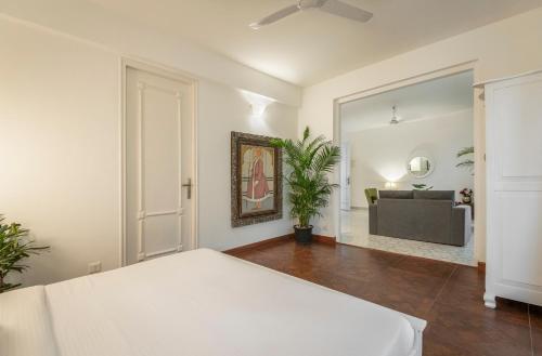 a bedroom with a bed and a living room at Santa Tera Homely 1&2bhk Apartments With Common Pool & Kitchen & Security & Wifi, Near to Candolim in Verem