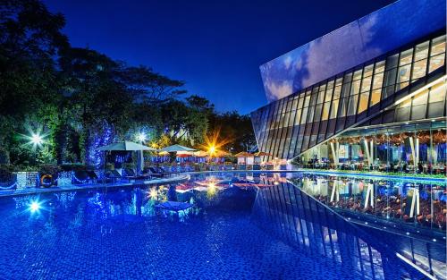 a large swimming pool in front of a building at night at Shenzhen Castle Hotel in Longgang