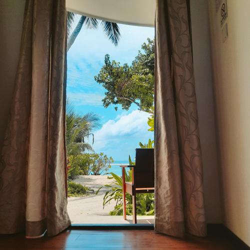 um quarto com uma janela com vista para a praia em Thundi Sea View em Fulidhoo