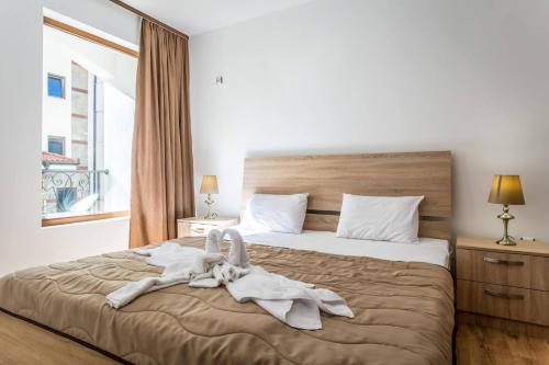 um quarto com uma cama com toalhas em Апартамент за гости Villa Ravda em Ravda
