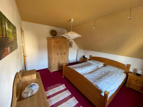 1 dormitorio con cama de madera y mesa de madera en Ferienhaus Elisabeth-Erzgebirge, en Olbernhau