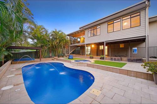 a swimming pool in front of a house at Harrys @ Shelly Beach - family home with pool in Port Macquarie