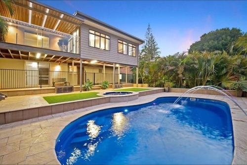 a house with a swimming pool in front of a house at Harrys @ Shelly Beach - family home with pool in Port Macquarie