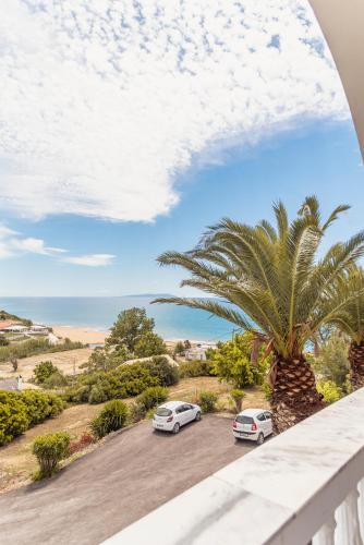 two cars parked in a parking lot with a palm tree at Adriatica View in Vitalades