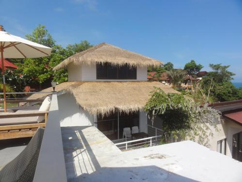 a resort with a thatched roof and a balcony at High Life Bungalow in Haad Yao