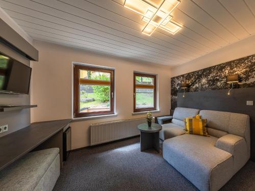 a living room with a couch and a tv at Paulshöhe in Waren