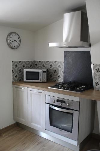 une cuisine avec une cuisinière et un micro-ondes dans l'établissement Appartement le Gambetta, à Cotignac