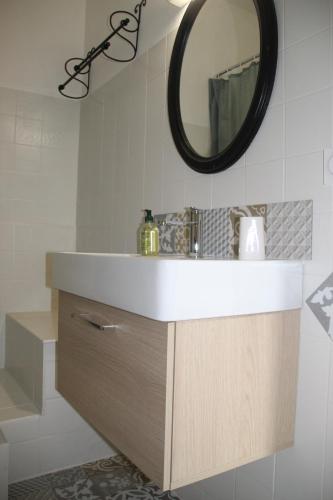 une salle de bain avec un lavabo et un miroir dans l'établissement Appartement le Gambetta, à Cotignac