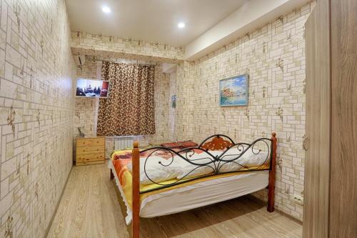 アドレルにあるApartment Kurortnyi Gorodokのレンガの壁にベッド1台が備わるベッドルーム1室