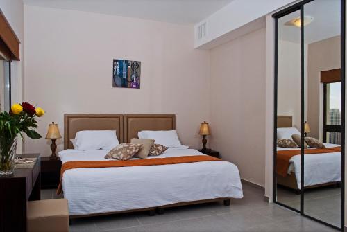 a hotel room with two beds and a mirror at Celino Hotel in Amman