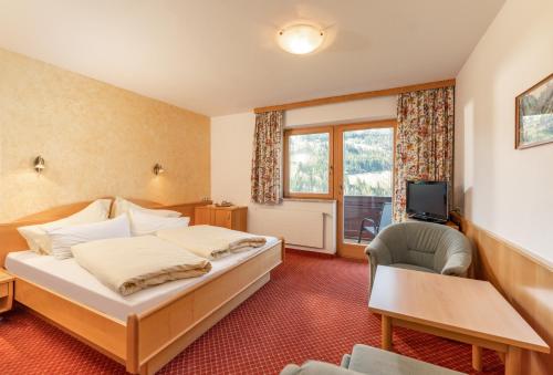 a hotel room with a bed and a television at Gästehaus Huber Frühstückspension in Schladming