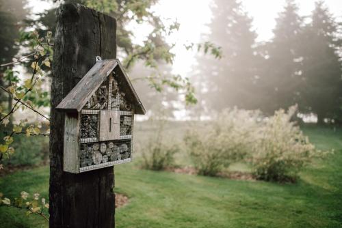 a bird house on a wooden post in a yard at Tiny House, Kleinod im Grünen in Emstek