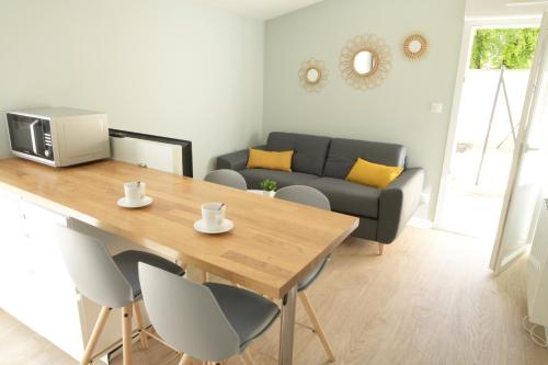 un salon avec une table et un canapé dans l'établissement T2 - 28m2 avec cour et stationnement, wifi et linge fournis, à Angoulême