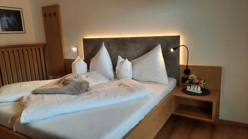 - un lit avec des draps et des oreillers blancs dans l'établissement Appartements Haus Olympia, à Innsbruck