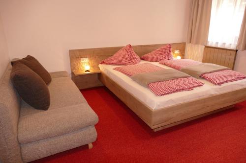1 dormitorio con 2 camas, sofá y silla en Vorderhof, en Sankt Martin am Tennengebirge