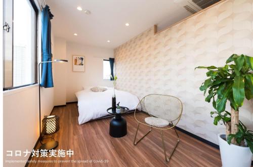 a room with a bed and a chair and a window at TORA HOTEL Tokyo Skytree 寅ホテル スカイツリーF in Tokyo