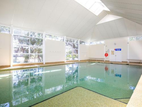 a swimming pool with a glass floor in a building at Sapphire Sands - Pet Friendly - Community Pool in Callala Beach