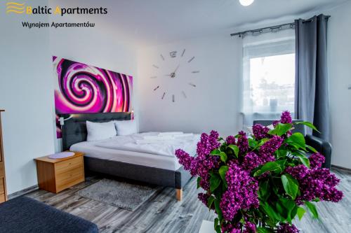 sypialnia z łóżkiem i zegarem na ścianie w obiekcie Baltic Apartments - Apartament Słoneczny Taras w Świnoujściu
