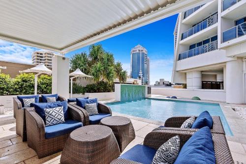 an outdoor patio with furniture and a swimming pool at H Luxury Residence Apartments - Holiday Paradise in Gold Coast