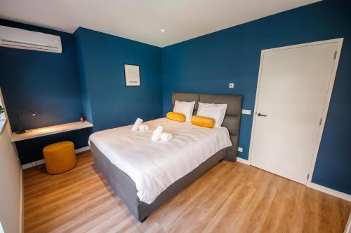 een slaapkamer met een groot bed met blauwe muren bij Boutique Chic 55m2 Apartment with City Garden in Den Bosch