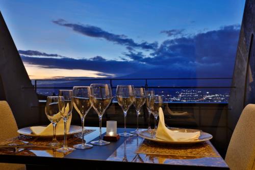 a table with wine glasses on a balcony with a view at Rembrandt Premium Fuji Gotenba in Gotemba