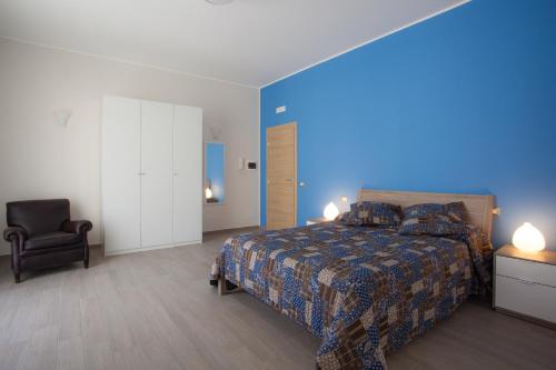 - une chambre avec un lit et une chaise dans l'établissement B&B Il Sole Blu, à Trapani