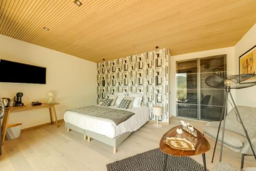 a bedroom with a bed and a desk and a television at La Possibilité d'une Ile in Apt