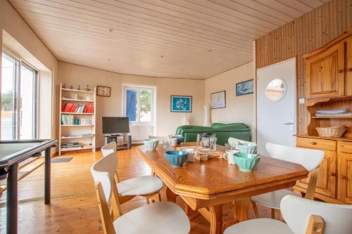 une salle à manger avec une table et des chaises en bois dans l'établissement Maison pour 6 - jardin et terrasse - 300m plage, à Bretignolles-sur-Mer
