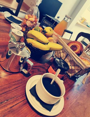 Chateauroux-les-AlpesにあるChambres d'hôtes Les Peschiersの木のテーブルの上にフルーツが置かれたコーヒーカップ