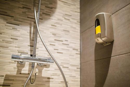 a shower in a bathroom with a phone on the wall at Trendy Design 55m2 Apartment with Balcony - DB6B in Den Bosch