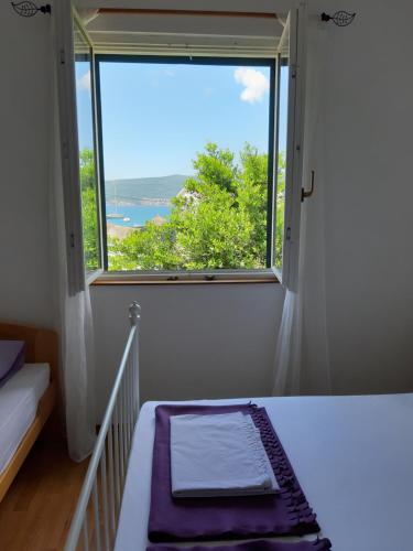 a bedroom with a window with a view of the ocean at Apartmani Stipanic Tivat in Tivat