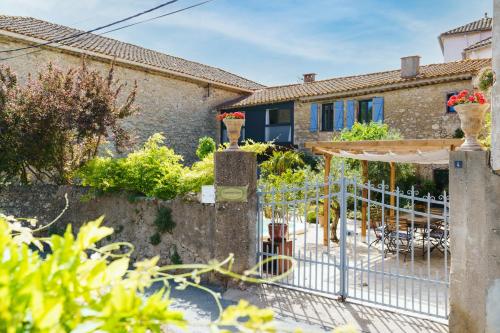 a house with a gate and a garden at Logement Onze Chambres & Gîtes in Raissac-dʼAude