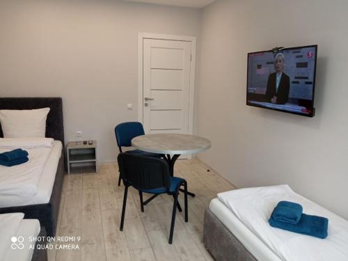 a small room with a table and a tv on the wall at HotelRoom 1 in Uzhhorod