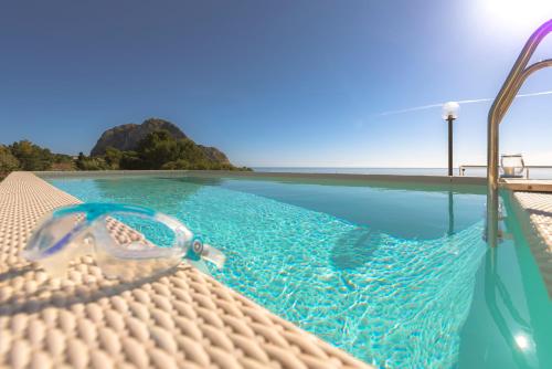 a pair of goggles sitting on the edge of a swimming pool at Dimore di mare - Beachfront Apartments in Santa Flavia