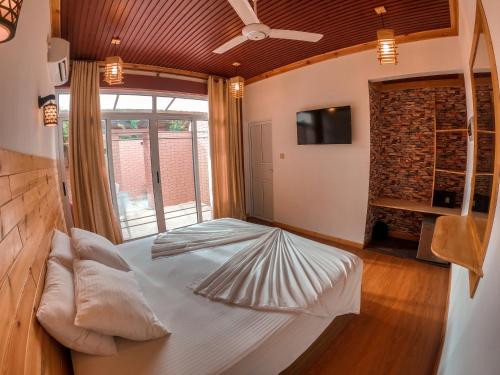 a large bed in a room with a large window at New Breeze Thoddoo Inn in Thoddoo